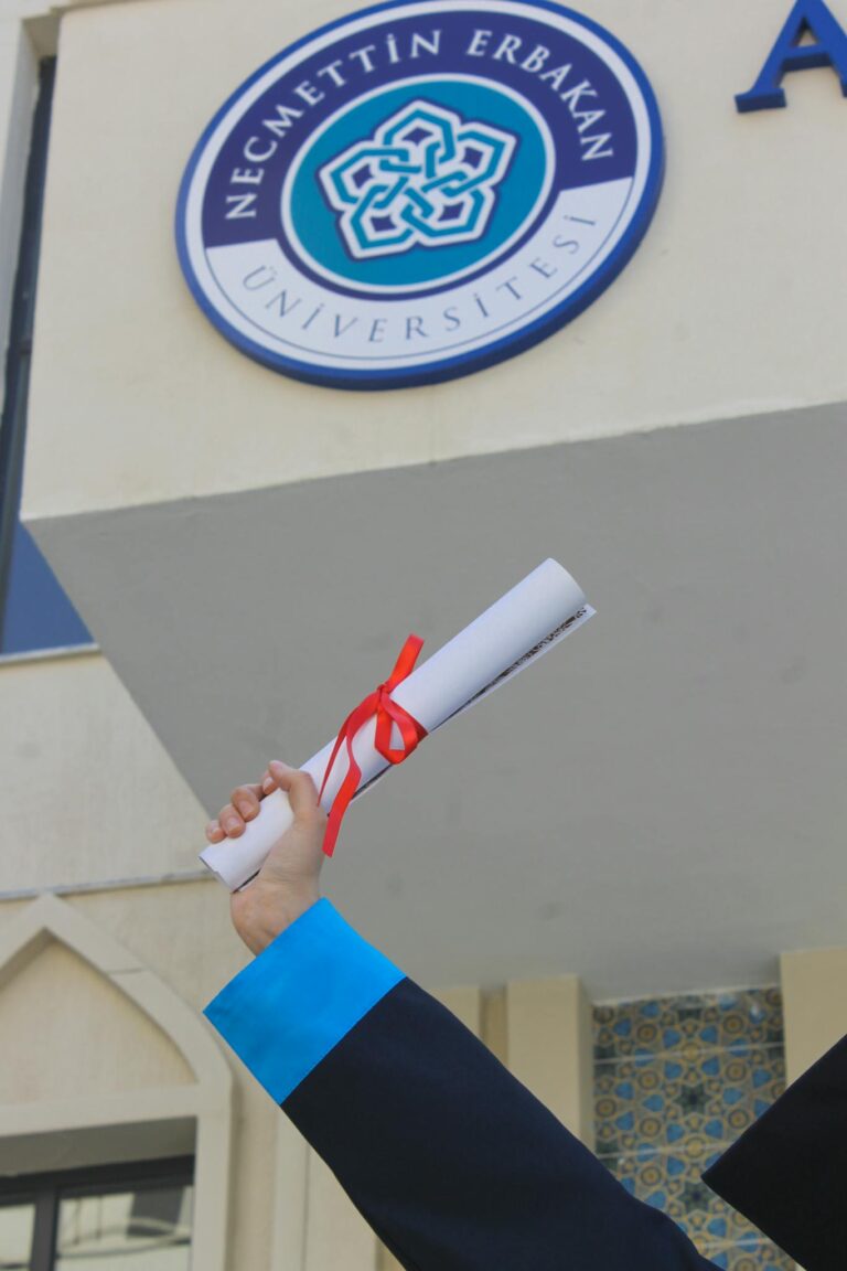Graduate holding diploma against Necmettin Erbakan University sign. Celebrate success.